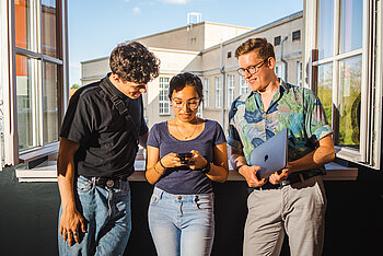 Three students looking on a mobile phone